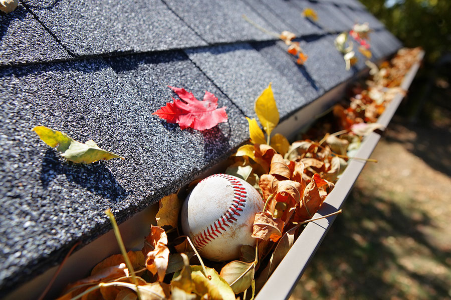 Rain gutter full of leaves in need of gutter cleaning