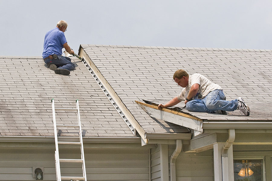 Contractors Inspecting and Repairing Roof of Home