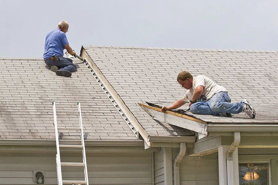 Contractors Inspecting and Repairing Roof of Home
