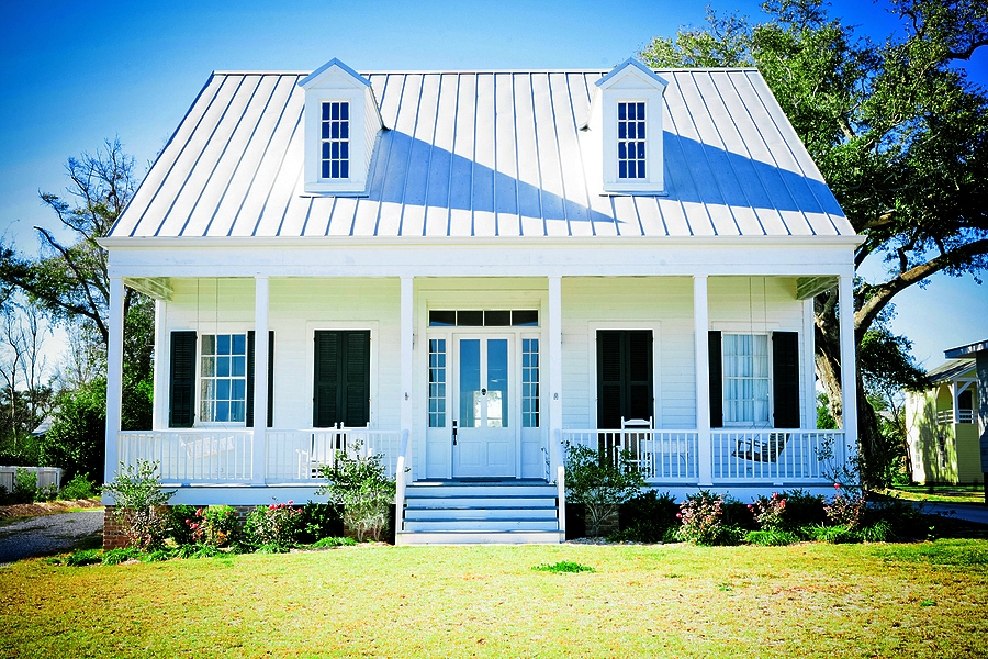 Small White Beach Cottage With A Metal Roof, Dormer Windows, And Metal Roofing